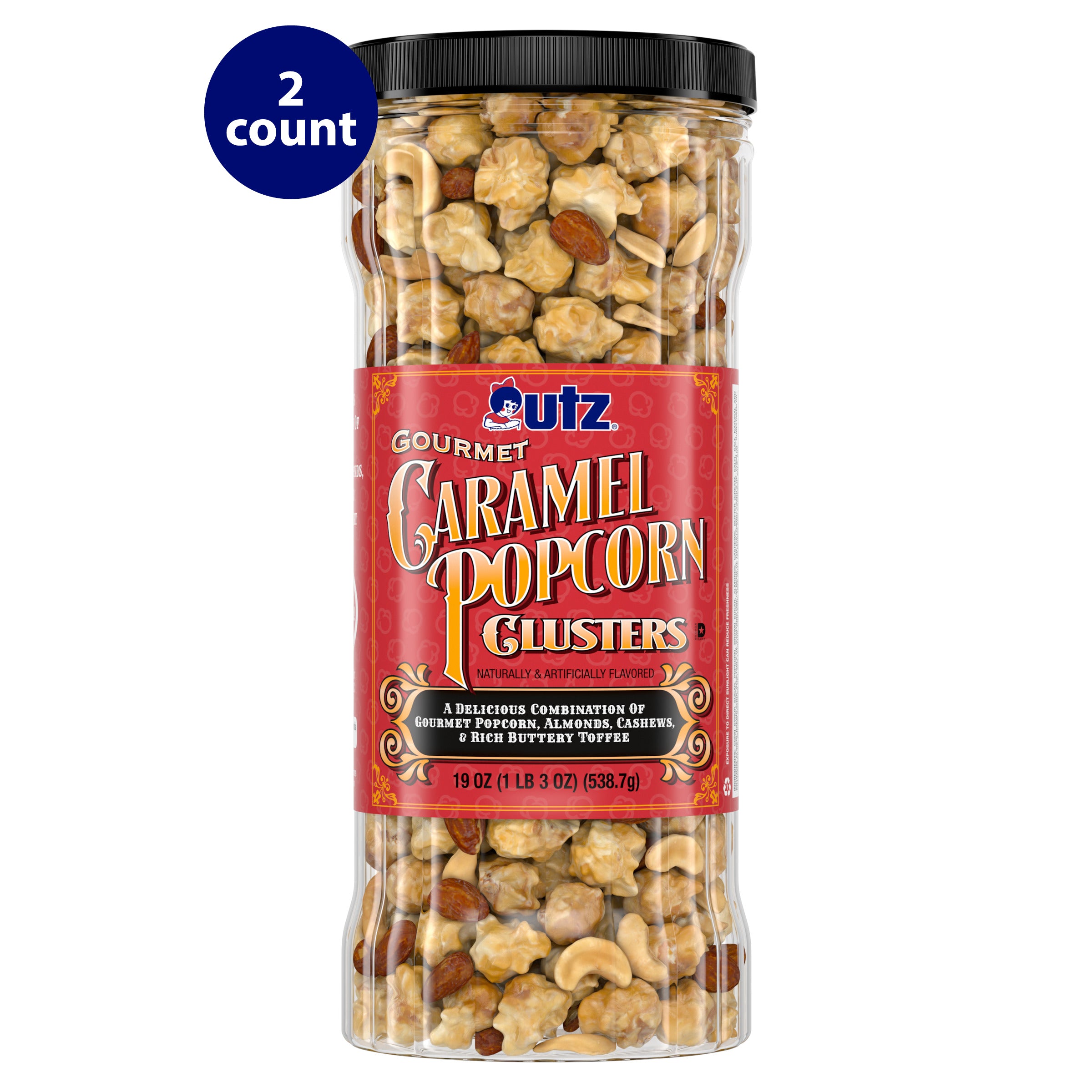A tall, clear container of Utz Gourmet Caramel Popcorn Clusters with a black lid. The red label features the Utz logo and product name in ornate, gold-accented lettering. It describes a mix of caramel-coated popcorn, almonds, cashews, and rich buttery toffee. The container holds 19 oz (1 lb 3 oz) or 538.7g, and a “2 count” label is visible in the top left corner.