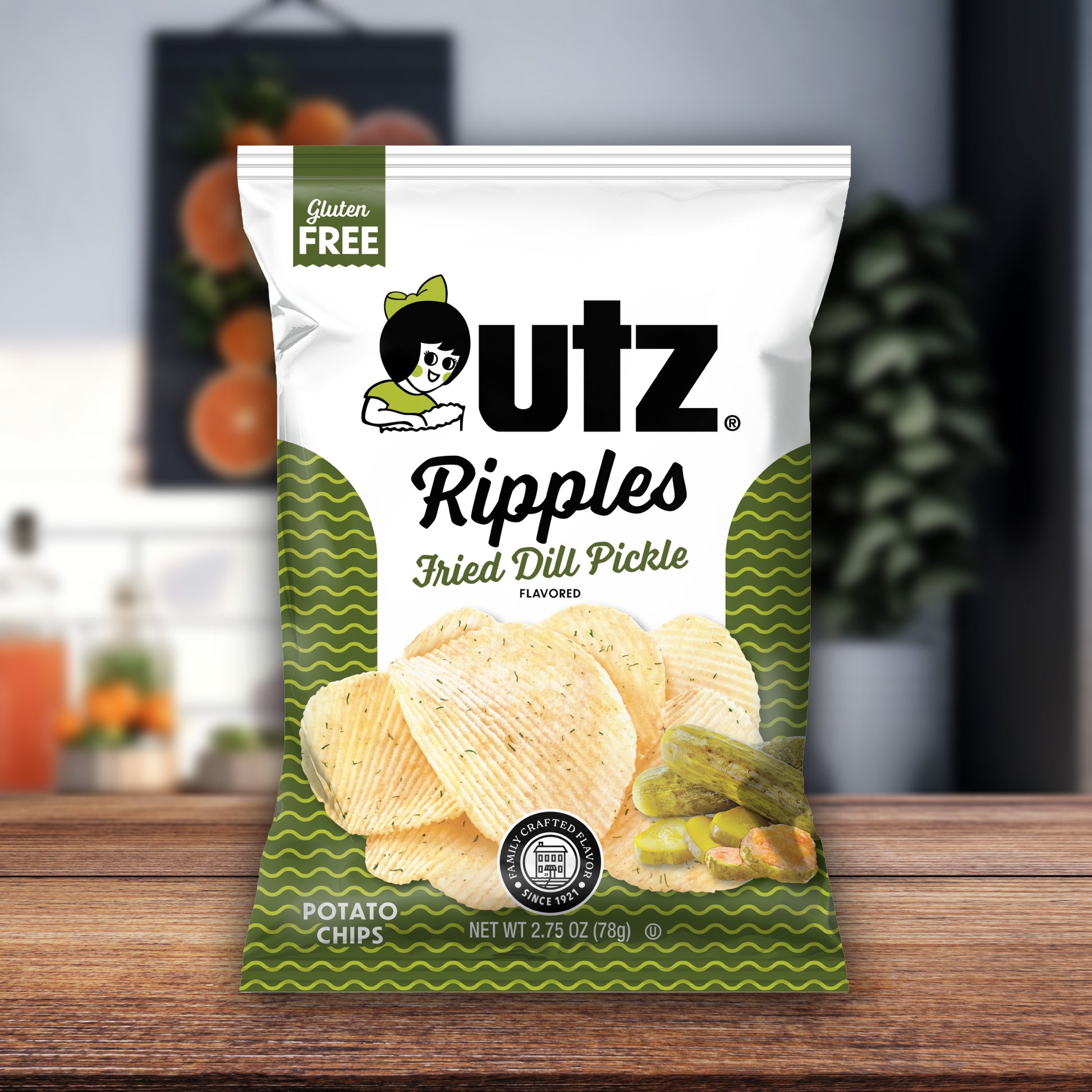 UTZ Ripples Fried Dill Pickle flavored potato chips packaging on a wooden surface with a blurred background.
