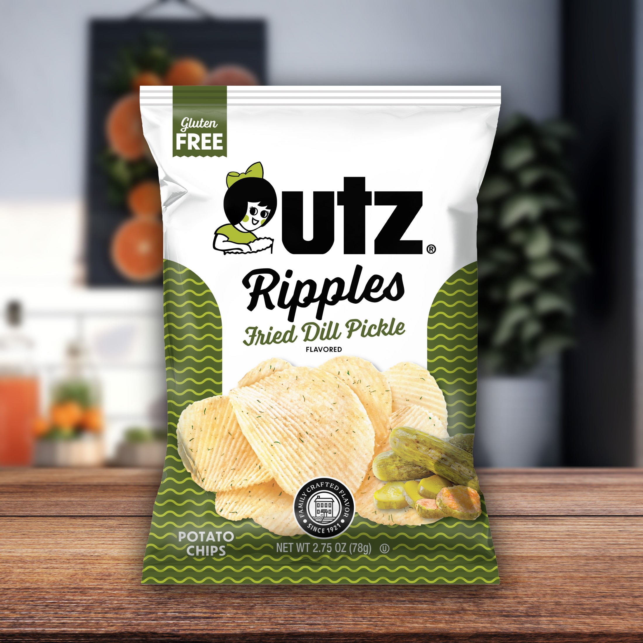 UTZ Ripples Fried Dill Pickle flavored potato chips packaging on a wooden surface with a blurred background.