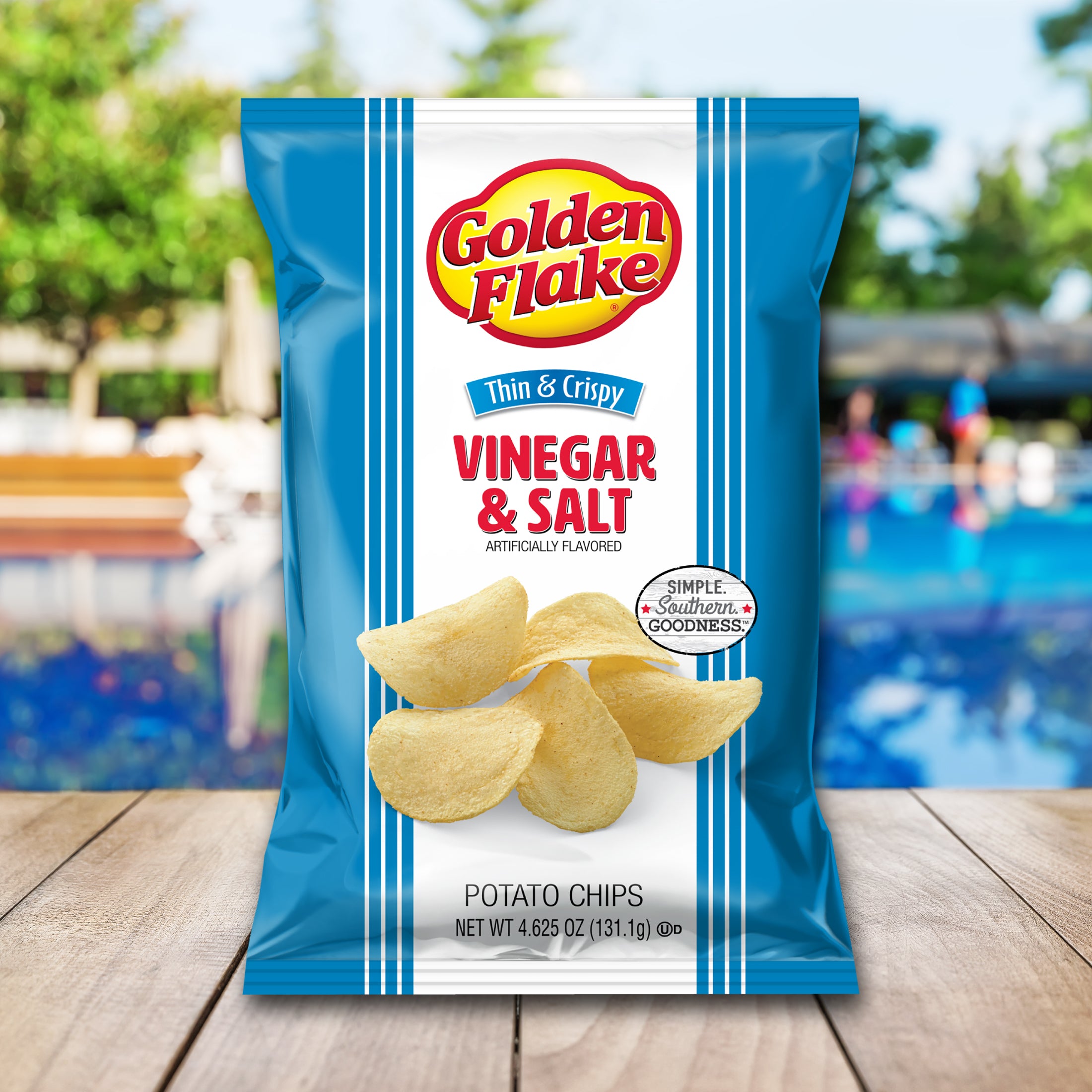 Packaging of Golden Flake vinegar and salt potato chips with a blurred outdoor background