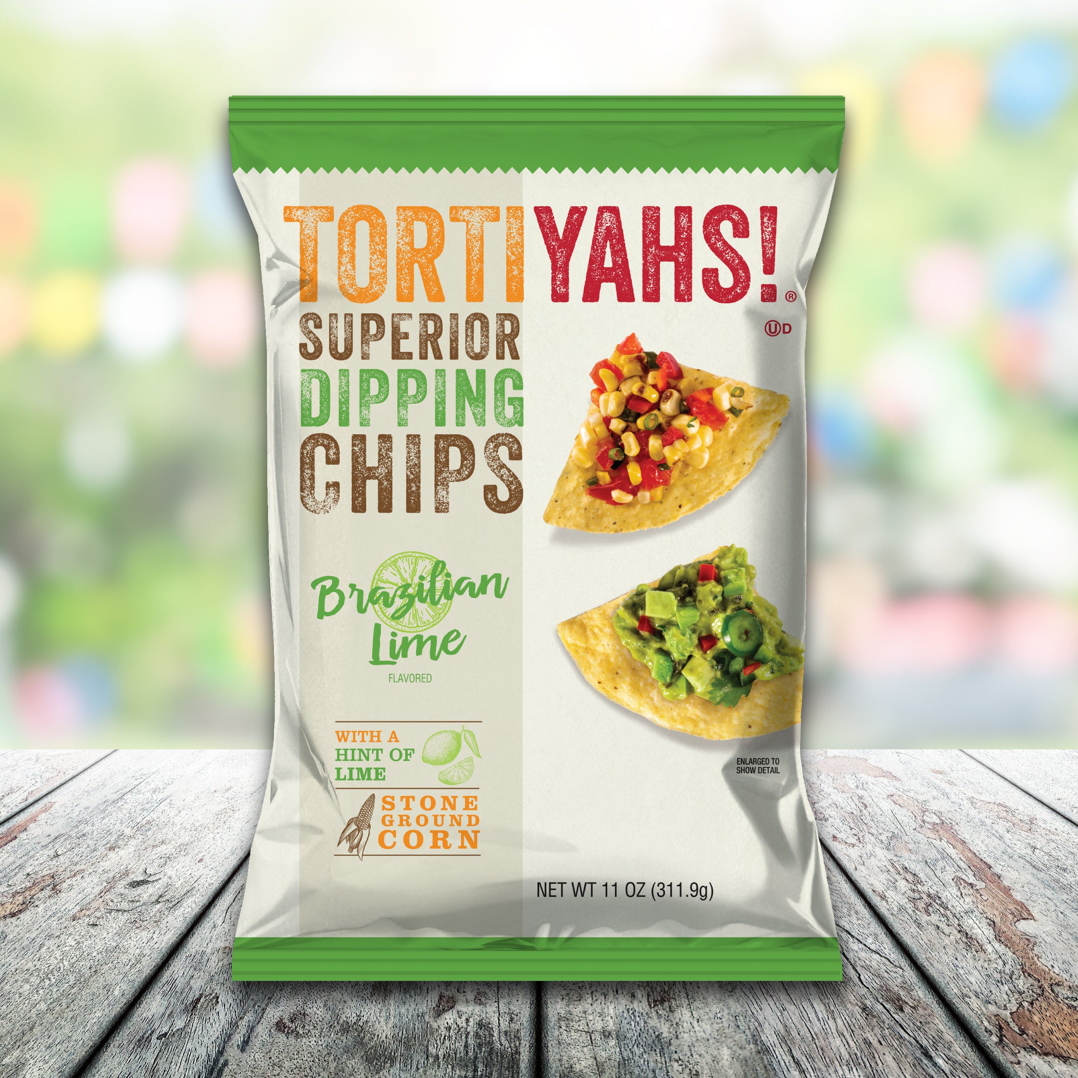 Tortiyahs! Superior Dipping Chips packaging on a wooden surface with a blurred colorful background