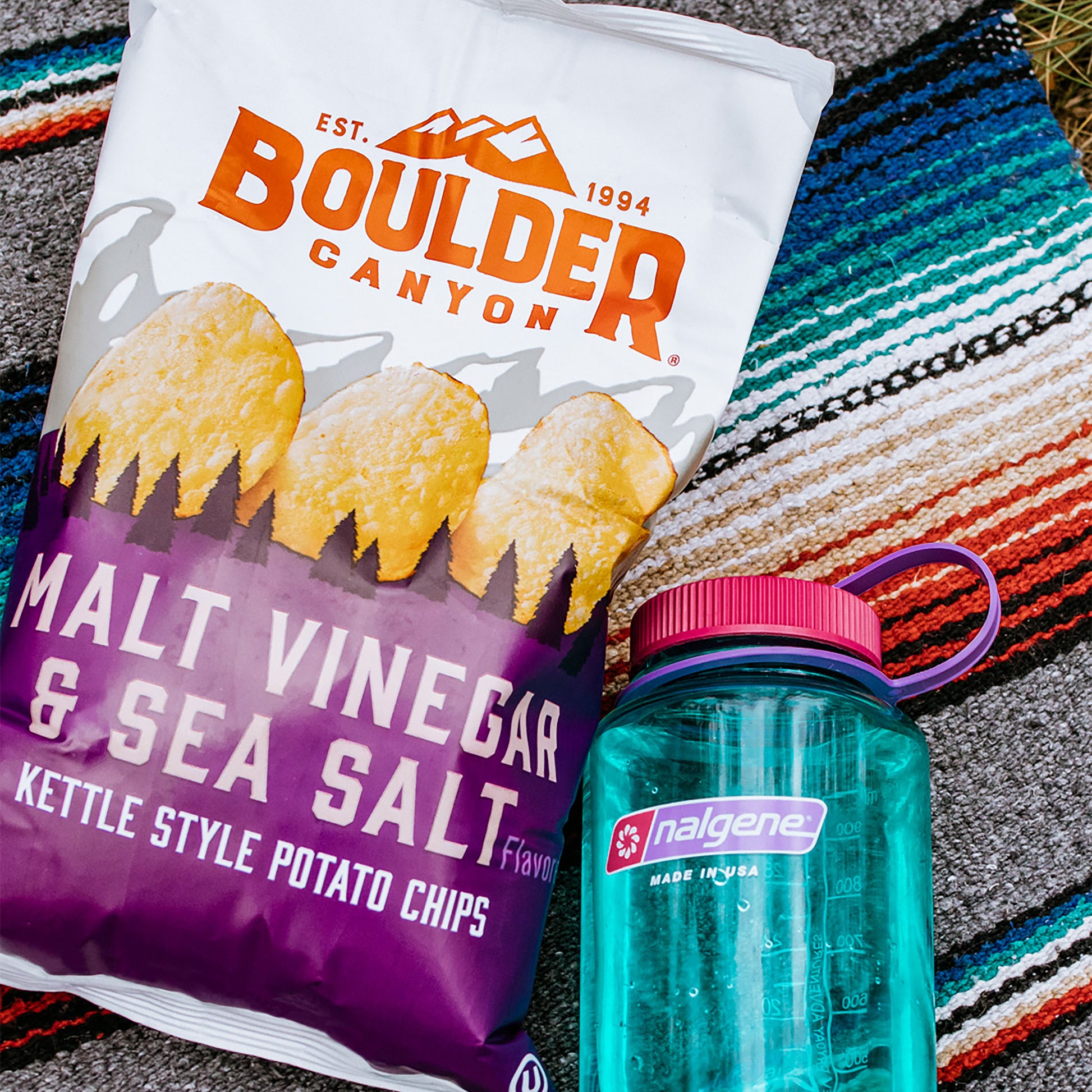 Boulder Canyon potato chips bag and Nalgene water bottle on a textured surface