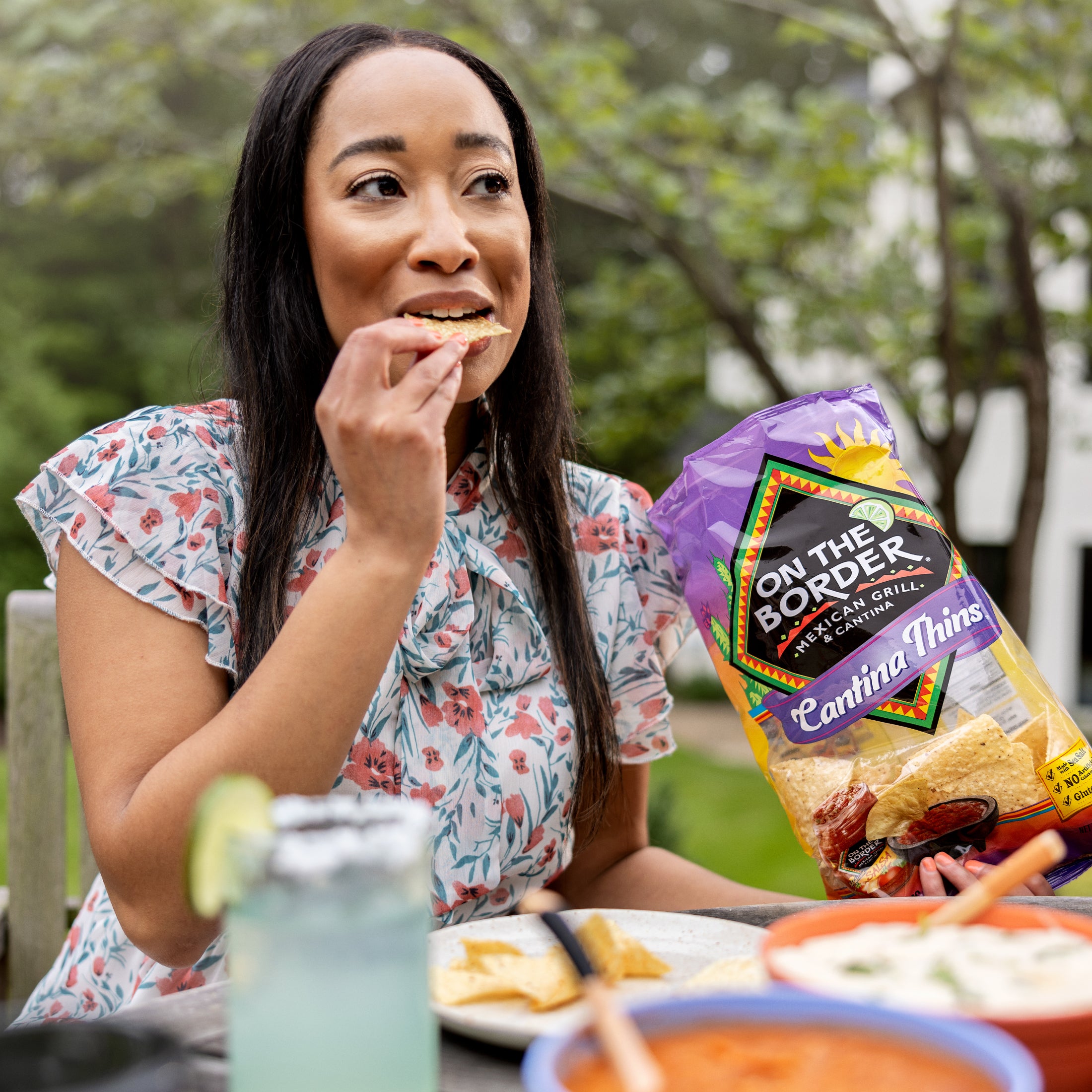 Person enjoying On The Border Cantina Thins tortilla chips outdoors