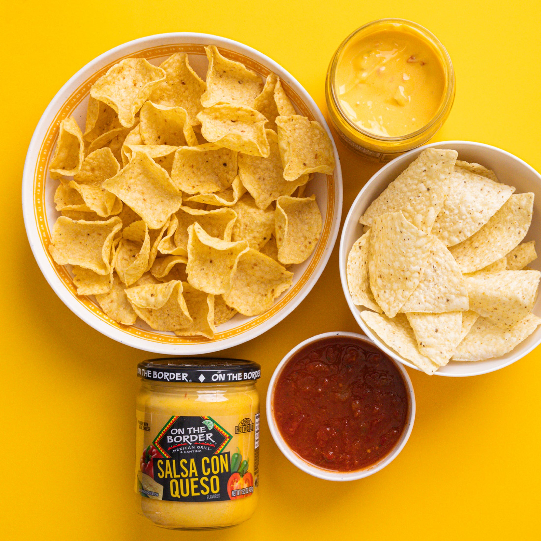 Tortilla chips with salsa and queso on a yellow background