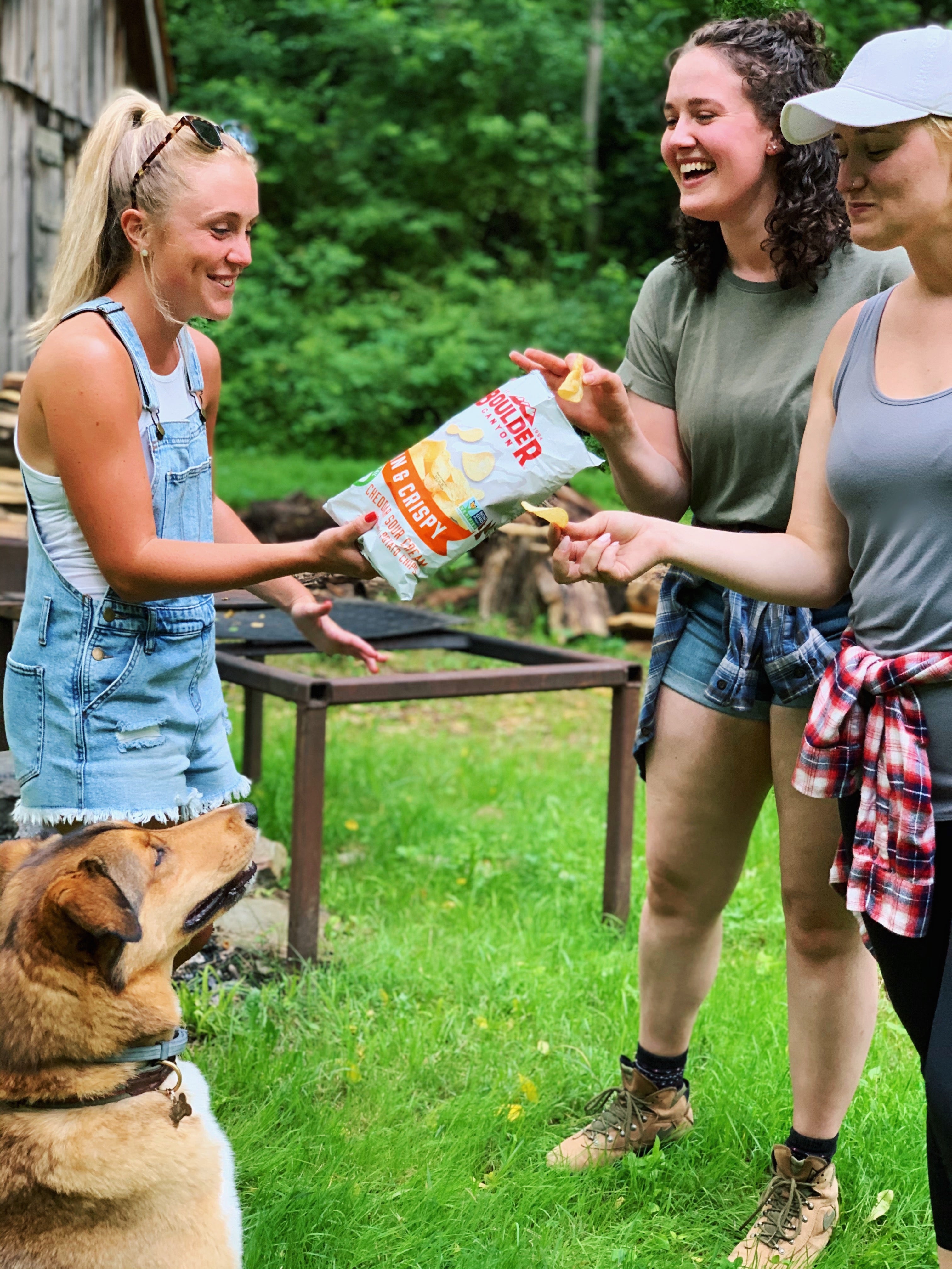 Friends outdoors sharing Boulder Canyon honey barbecue chips.