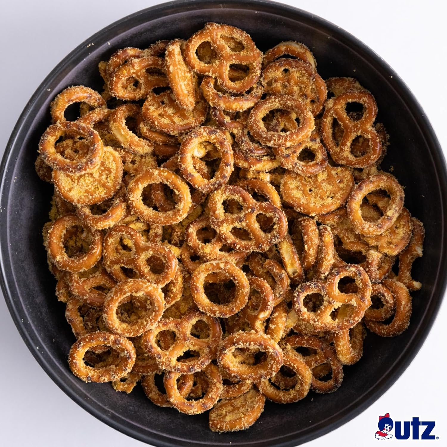 Black bowl filled with pretzel rings on a white background, featuring the Utz logo.