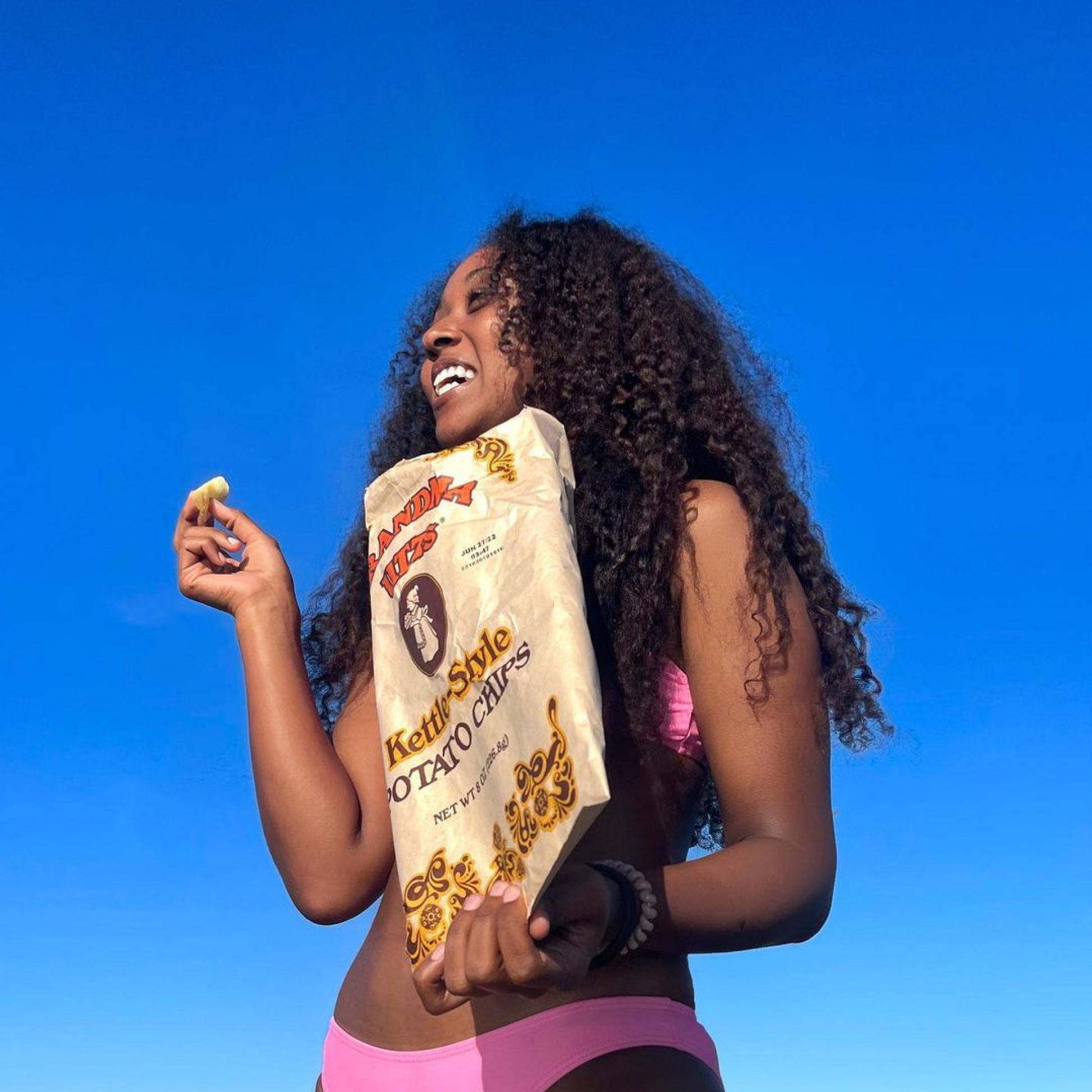 Woman holding Grandma Utz Kettle Style Potato Chips at the beach