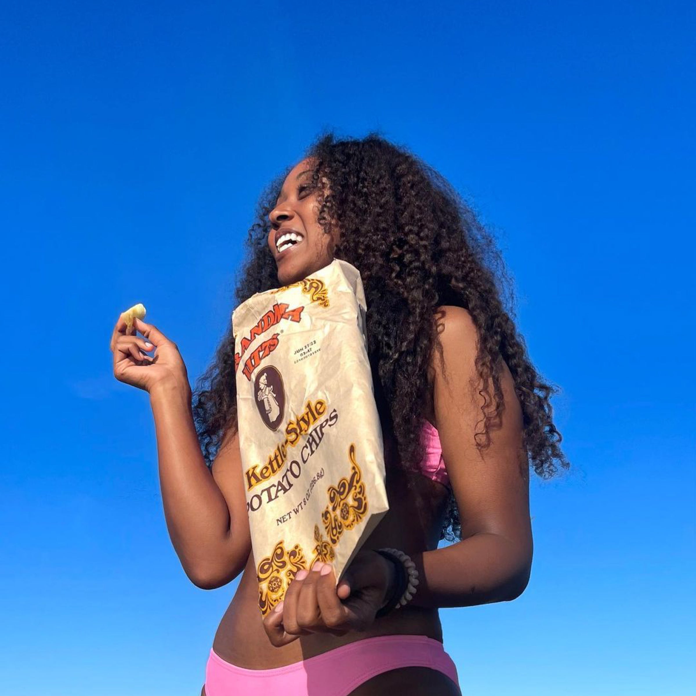 Woman holding Grandma Utz Kettle Style Potato Chips at the beach